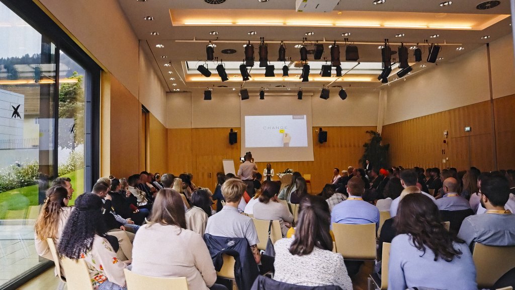 Eine Gruppe von Menschen bei einem Business Meeting in einem Konferenzsaal.